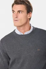 Buzo tejido de lana con escote redondo a la base, de manga larga y calce clásico.