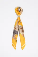 Pañuelo de seda sintética color amarillo con estampado de perros yorkshire, incluye una pieza metálica central con el logo de la marca.