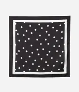 Pañuelo cuadrado de satén con estampado de lunares blancos sobre fondo negro. Accesorio versátil de tejido fluido, ideal para usar en el cuello, el cabello o como detalle en bolsos.