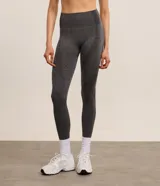 Legging deportiva de tiro alto confeccionada en tejido seamless color gris melange. Presenta un diseño ajustado con paneles texturizados en los laterales que ofrecen un efecto modelador y levanta pompis.