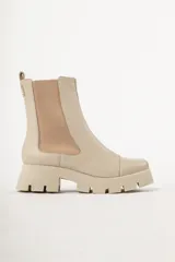 Bota tipo chelsea de caña media, color beige, con paneles laterales elásticos y suela track de plataforma dentada.
