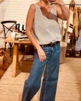 Cinto de cuero negro con hebilla metálica plateada y tachas plateadas.