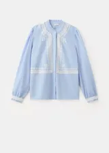 Camisa celeste de algodón con cuello mao, diseño recto, mangas largas abotonadas y detalles bordados con terminaciones festoneadas.