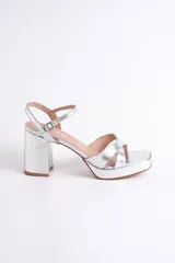 Sandalias negras de cuero sintético con plataforma y tacón cuadrado. Presentan tiras cruzadas en el empeine y pulsera con hebilla al tobillo.