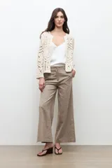 Chaqueta tejida a crochet en color beige claro, de diseño abierto y manga larga con patrones geométricos calados.