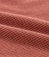 Remera de hombre color terracota, corte regular, cuello redondo y manga corta. Presenta un pequeño bordado de una palmera en el lado izquierdo del pecho.