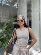 Top musculosa beige de tela Morley Fine Lines elastizada, con textura rib bicolor y detalle de tachas en el vivo de la manga.