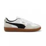 Championes Puma modelo Palermo LTH, con diseño de inspiración retro en cuero blanco, detalles en gamuza beige y la característica franja lateral en gamuza negra. Cuenta con suela de goma color caramelo y logo dorado en el lateral.