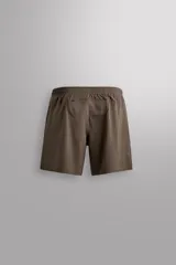 Pantalón corto deportivo color marrón oliva, confeccionado en tejido técnico ligero y elástico, con forro interior. Presenta cintura elástica ajustable con cordón, bolsillos frontales, bolsillo de seguridad trasero con cierre y aberturas laterales en el bajo.