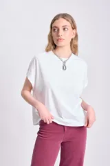 Camiseta blanca de algodón con corte holgado y mangas cortas tipo sisa.
