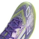 Championes de fútbol Adidas F50 League FG, color violeta con detalles en amarillo y blanco. Presentan ajuste regular, cierre de cordones, parte superior de Fiberskin con estampado Sprintgrid y suela Sprintplate 360 firme/multisuperficie.