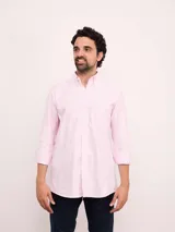 Camisa de corte regular confeccionada en tejido Oxford de algodón, con diseño de rayas verticales finas. Presenta cuello abotonado, cierre frontal con botones y un bolsillo en el pecho.