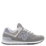 Championes urbanos New Balance modelo 574, color gris con detalles en blanco y gris claro. Confeccionados en una combinación de gamuza y tejido técnico, presentan el logo N característico en los laterales, entresuela ENCAP para mayor soporte y suela de goma con diseño inspirado en trail.