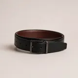 Cinturón reversible de cuero con hebilla metálica rectangular. Presenta una cara externa en color negro y una cara interna en color marrón.