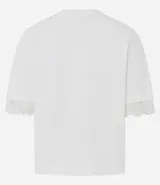 Remera de corte recto y calce confortable, confeccionada en algodón. Presenta cuello redondo y mangas cortas amplias con delicada aplicación de encaje en los bordes.
