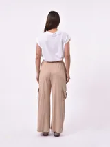 Pantalón negro de tiro alto con elástico en la cintura, corte ancho y bolsillos cargo a los lados.