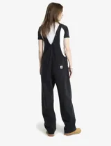 Enterito de jean Carhartt en color negro, con corte recto, tirantes ajustables y múltiples bolsillos frontales, incluyendo uno con el logo de la marca.