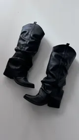 Botas negras de caña alta con efecto arrugado y punta cuadrada.