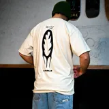 Remera color arena de corte oversize, con estampa en el pecho y gran diseño gráfico en la espalda en color negro, marca La Ola.