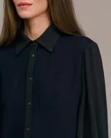 Camisa azul con mangas largas abullonadas, cuello italiano y corte entallado.