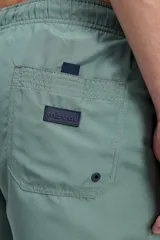 Short de baño azul, de corte clásico y largo corto, con cintura elástica y cordón ajustable bicolor. Cuenta con bolsillos laterales y uno trasero.
