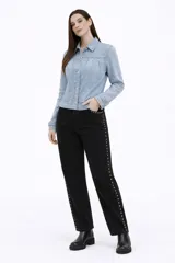 Campera de jean en tono celeste claro, con diseño de frunces en la parte superior delantera, mangas largas con puños ajustados y cierre frontal mediante botones metálicos.