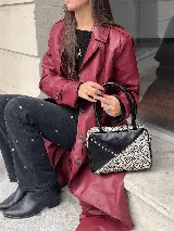 Cartera rígida negra con detalles en blanco y negro con estampado animal print. Tiene asa corta y correa larga extraíble.
