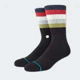 Medias crew de algodón peinado negras con banda superior a rayas horizontales en azul marino, rojo, blanco, gris claro y verde oliva. Presentan el logo de Stance en blanco en el lateral y detalle de costura turquesa en la puntera.
