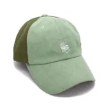 Gorra verde de corderoy con visera curva y logo de silla bordado en blanco.