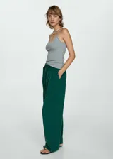 Pantalon wide leg color verde oscuro, con pinzas frontales, trabillas y cinturón integrado con hebilla circular. Cuenta con bolsillos laterales y cierre oculto.