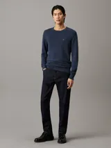 Sweater de manga larga color azul marino, con cuello redondo y tejido de punto micro piqué. Presenta un pequeño logo bordado en el pecho.
