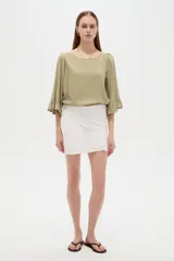 Falda mini de viscosa blanca con detalles de frunces y diseño cruzado.