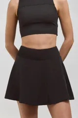 Pollera deportiva corta con calza incorporada, diseñada para actividades como pádel o tenis. Cuenta con cintura ancha de ajuste cómodo y bolsillo invertido en la calza para guardar pelotas. Confeccionada en tejido liviano y elastizado.