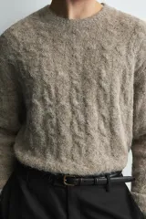 Jersey de punto con acabado cepillado, cuello redondo y manga larga. Presenta un diseño de trenzas verticales en toda la prenda y un corte relajado.