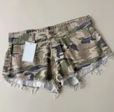 Short de denim con estampado camuflado, tiro medio, bolsillos clásicos y terminación desmechada en las piernas.