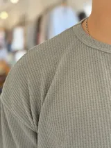 Remera oversize de tejido de punto color beige, de manga corta y cuello redondo.