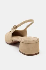 Zapato destalonado de serraje en color beige, con punta cuadrada, tira trasera ajustable con hebilla metálica dorada y tacón ancho bajo.