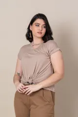 Remera color beige de algodón, con escote redondo con abertura en forma de gota y nudo en el frente.