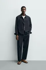 Sobrecamisa regular fit confeccionada en popelín de algodón color negro, con cuello solapa, bolsillos de plastrón en el pecho y cierre frontal con botones.