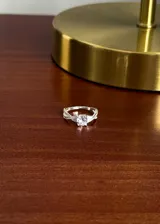 Anillo de plata 925 con diseño entrelazado decorado con microzirconias incrustadas y una piedra zirconia central de corte redondo.