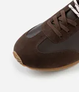 Championes estilo chutera vintage de la marca Satinato, confeccionados en poliuretano con diseño de recortes en gamuza sintética. Presentan punta redonda, cordones al tono y suela de goma dentada en color caramelo, con detalle de talón en contraste.
