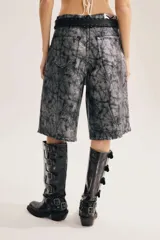 Bermuda de denim color gris con efecto acid wash y acabado brillante, de calce amplio y oversized. Cuenta con diseño largo hasta la rodilla, roturas y ruedo deshilachado.