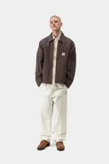Chaqueta Detroit de Carhartt WIP color marrón, de corte recto con cierre frontal de cremallera, cuello clásico de pana y bolsillos laterales. Cuenta con un bolsillo con cierre en el pecho decorado con la etiqueta del logo de la marca.