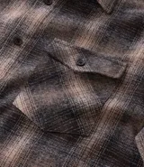 Camisa de manga larga confeccionada en franela de algodón, con diseño de cuadros, cuello inglés, cierre frontal con botones y un bolsillo en el pecho.