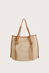 Bolsa tipo tote de textura tejida en color natural, con detalles de ribetes, asas y cordones decorativos en cuero sintético color suela.