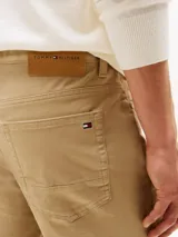 Pantalón de estilo clásico y corte recto, confeccionado en tejido twill de algodón con elasticidad. Presenta un diseño tradicional de cinco bolsillos, cierre de botón con cremallera y detalles distintivos de la marca.