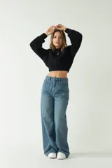 Sweater tejido de punto grueso color crema, con textura chunky, corte cropped, mangas abullonadas y puños ajustados.