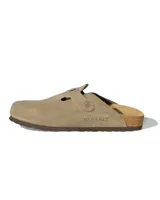 Zuecos de gamuza color beige con diseño de punta cerrada y ajuste lateral mediante tira con hebilla metálica grabada. Presentan una plantilla anatómica de corcho y látex, con suela de goma antideslizante.