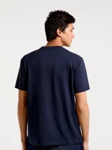 Camiseta blanca de algodón con cuello redondo y mangas cortas. Estampa rectangular con borde negro que contiene la frase "NATURAL ATMOSPHERE" en letras mayúsculas y una imagen de montañas y mar.