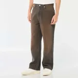 Pantalón de jean con corte baggy y pierna ancha, con efecto de lavado vintage en tono marrón oscuro. Cuenta con diseño clásico de cinco bolsillos, cierre frontal con botón y trabillas para cinturón.